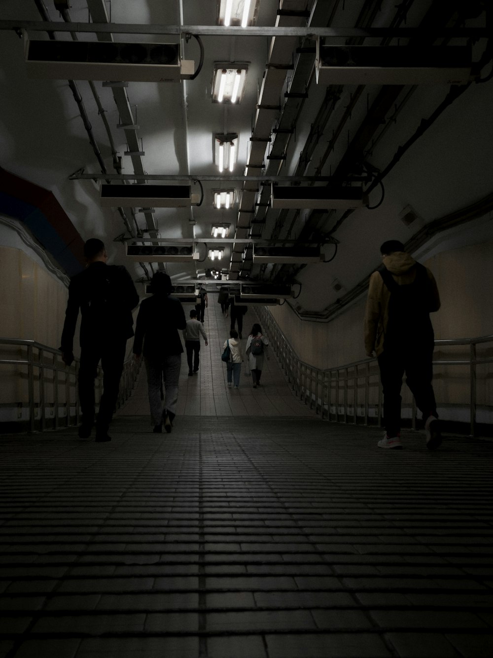 a group of people walking down a long hallway