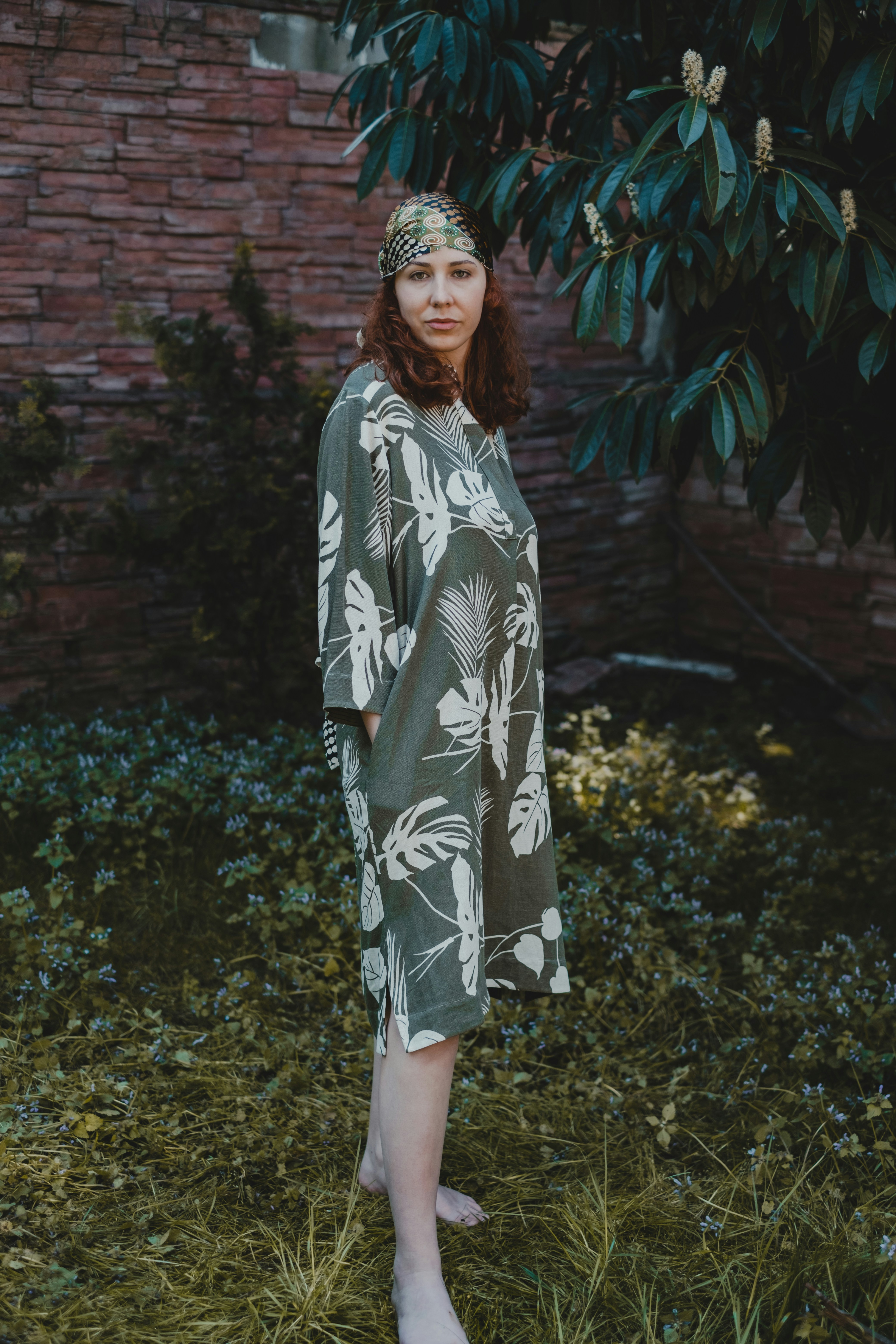 woman in black and white floral long sleeve dress standing on green grass field