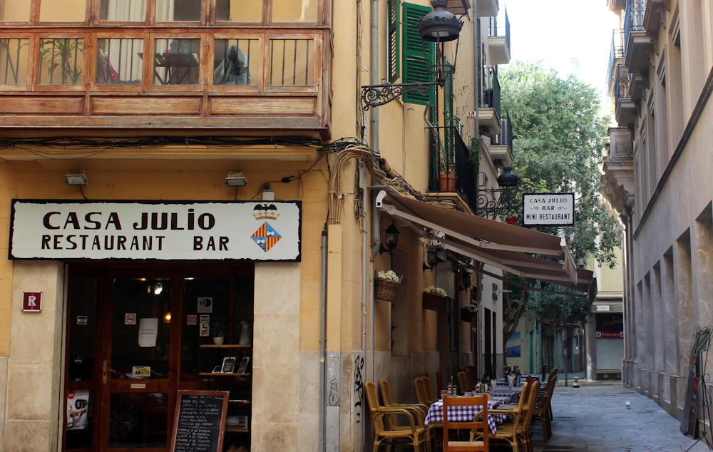 brown wooden chairs and tables outside store during daytime