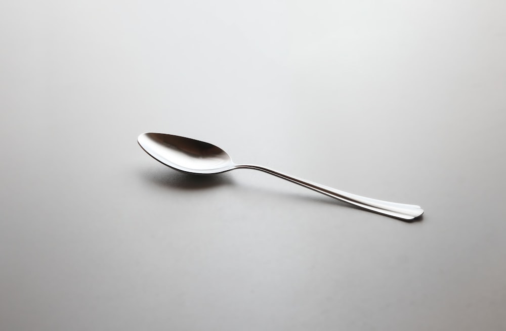 cucchiaio d'argento su tavolo bianco