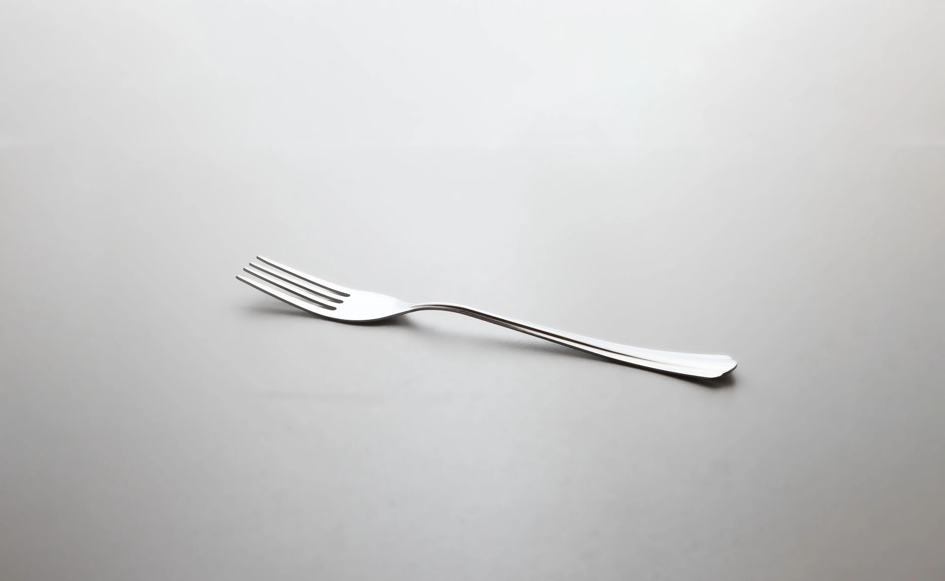 silver fork on white surface