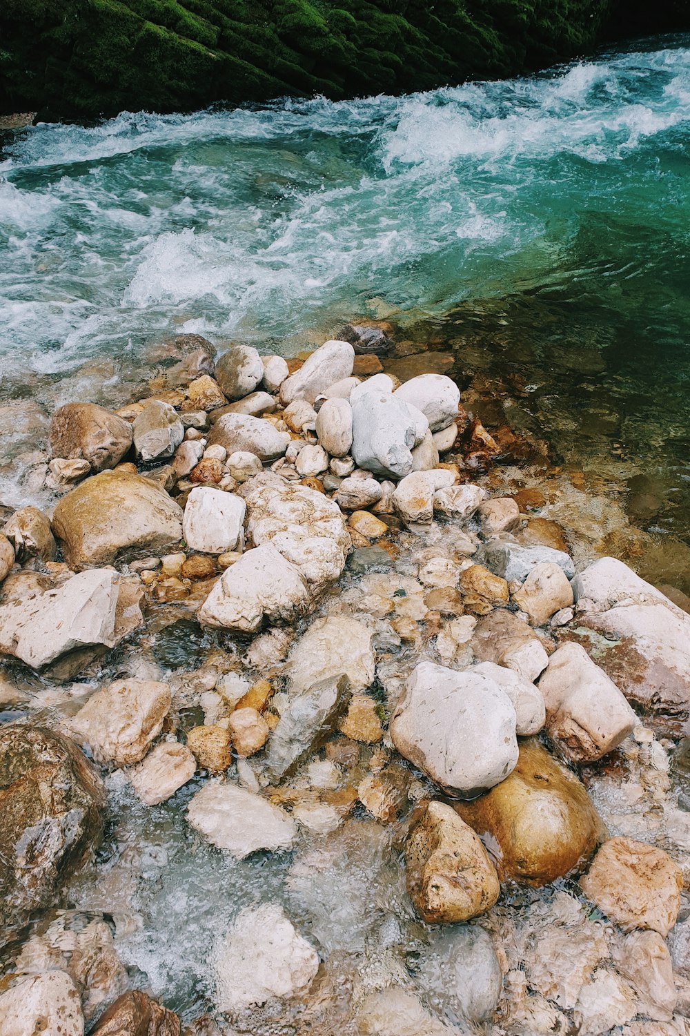 brown and gray rocks beside body of water