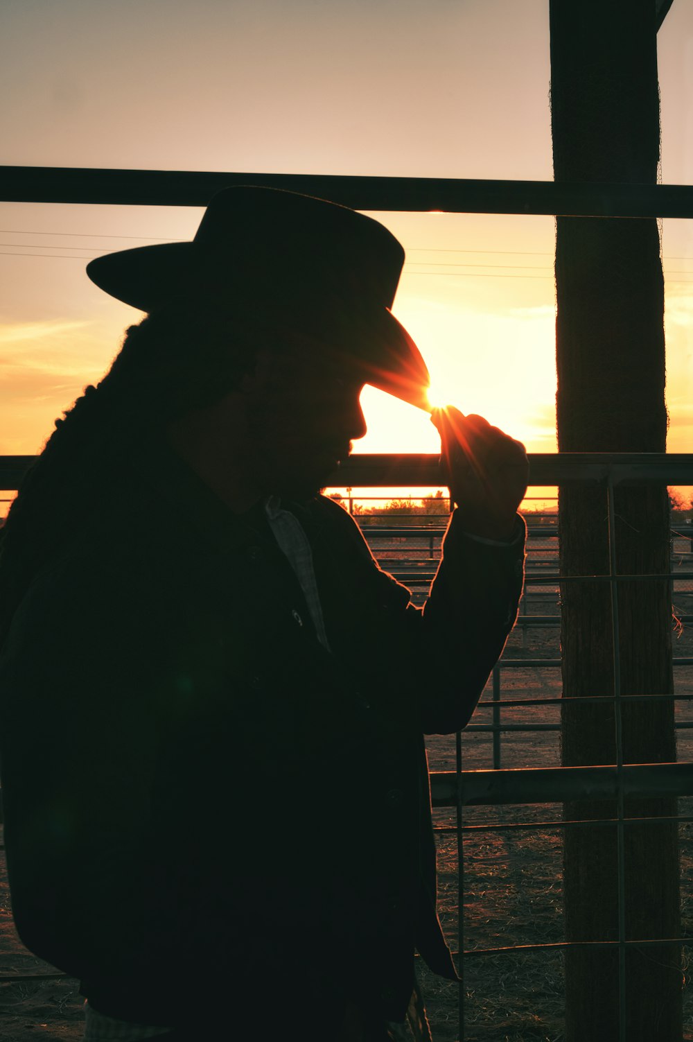 silhouette of man smoking cigarette during sunset