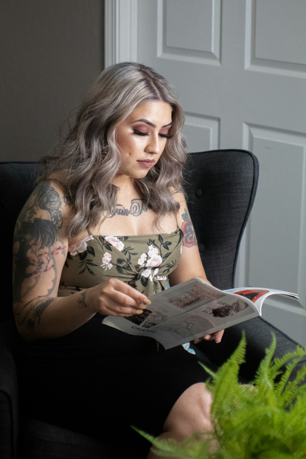 woman in white and brown floral tank top reading book