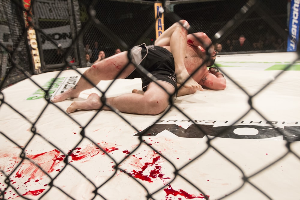 a man laying on top of a wrestling ring