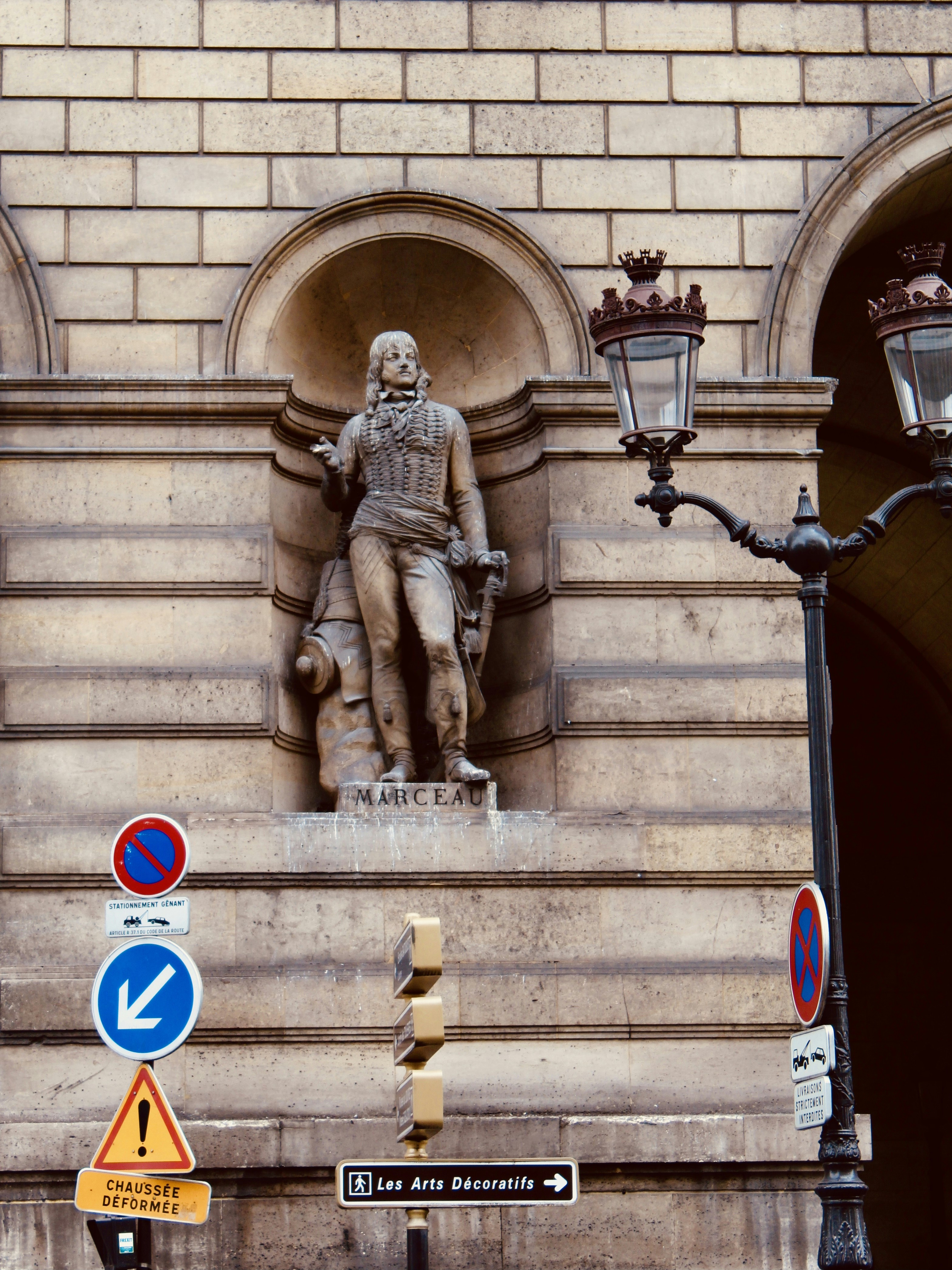 Statue d’homme en robe sur un escalier en béton brun