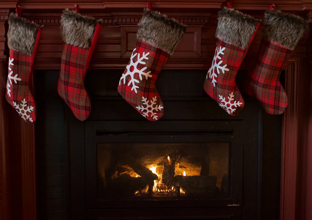 red and white christmas stocking hanged on fireplace