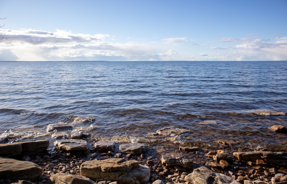 gray rocks near body of water during daytime