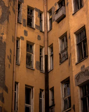 A close-up of a worn house facade with peeling paint and broken windows.