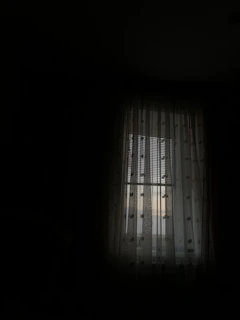 Soft silver moonlight filtering through sheer curtains in a cozy, darkened room.