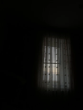 Soft silver moonlight filtering through sheer curtains in a cozy, darkened room.