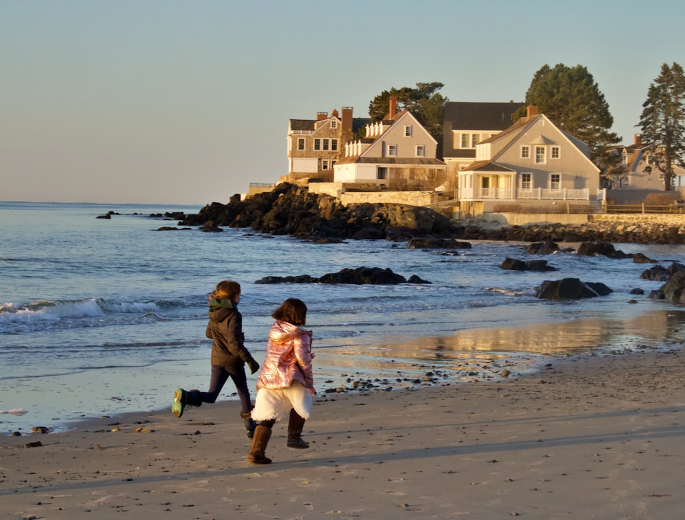 man and woman walking on beach during daytime