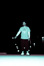 A sleek urban streetwear outfit with black and gray tones glowing subtly under city lights.