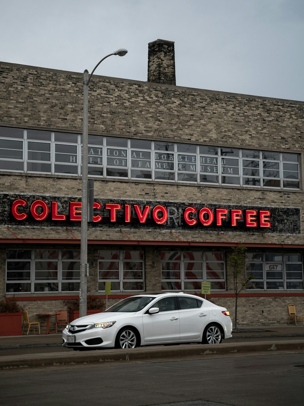 a white car parked in front of a coffee shop