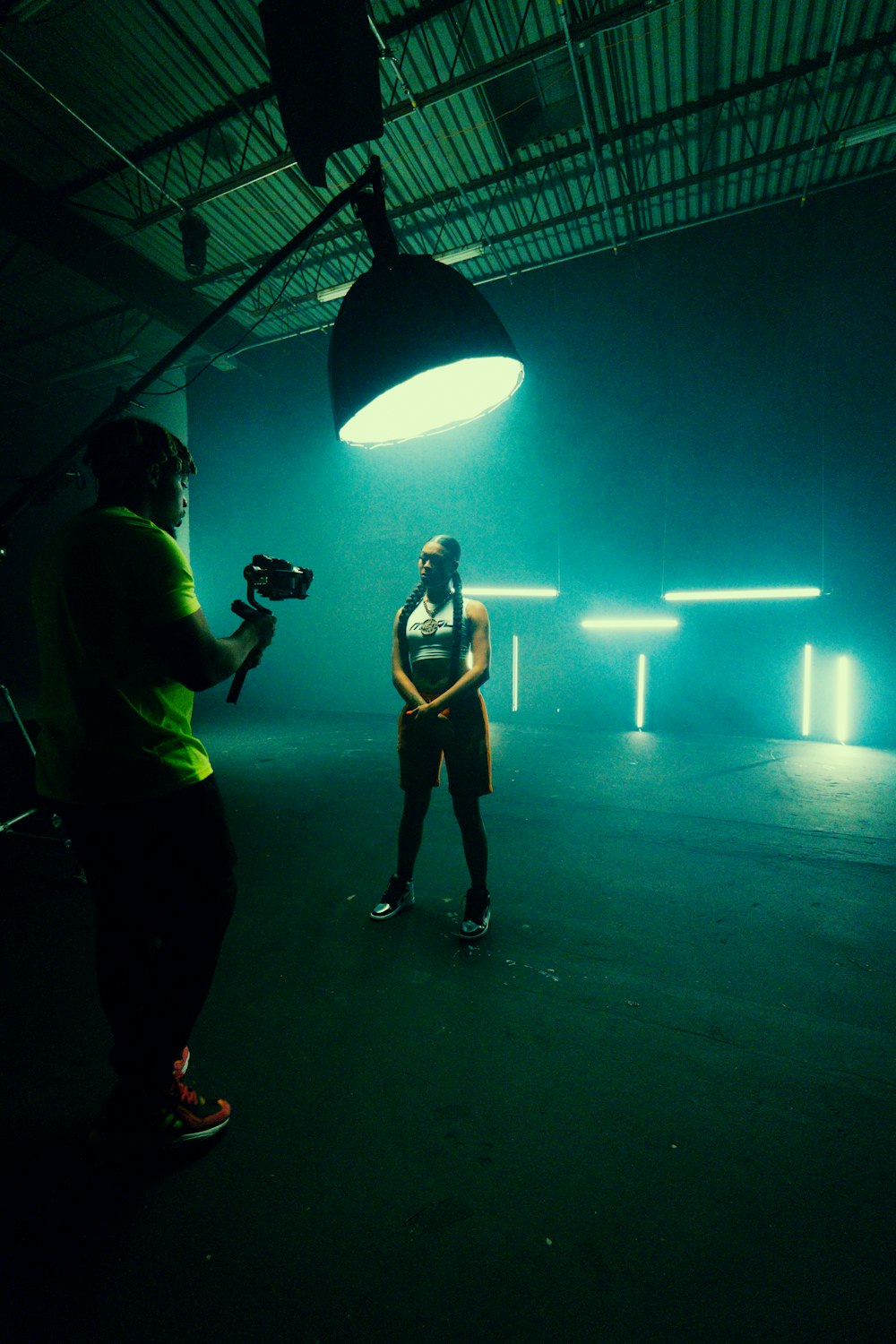 man in black t-shirt and black pants holding black dslr camera