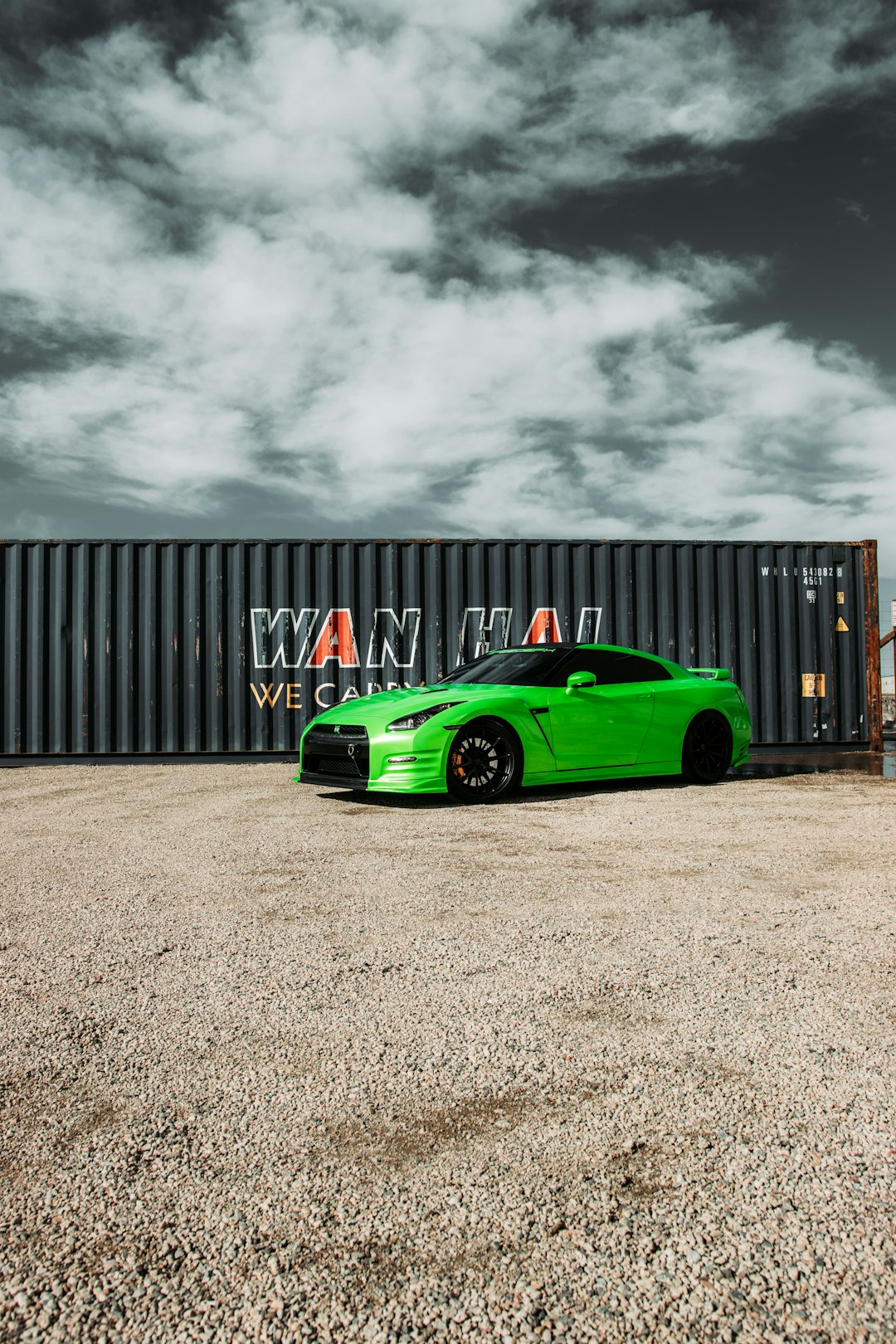 green ferrari sports car parked near gray building