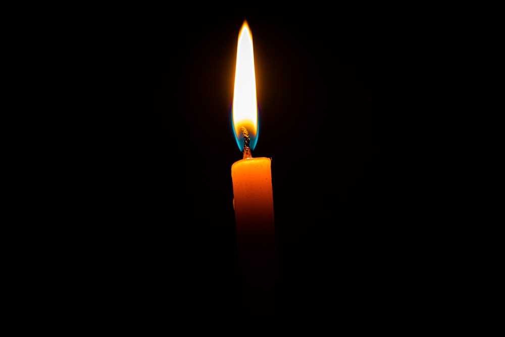 lighted candle in dark room