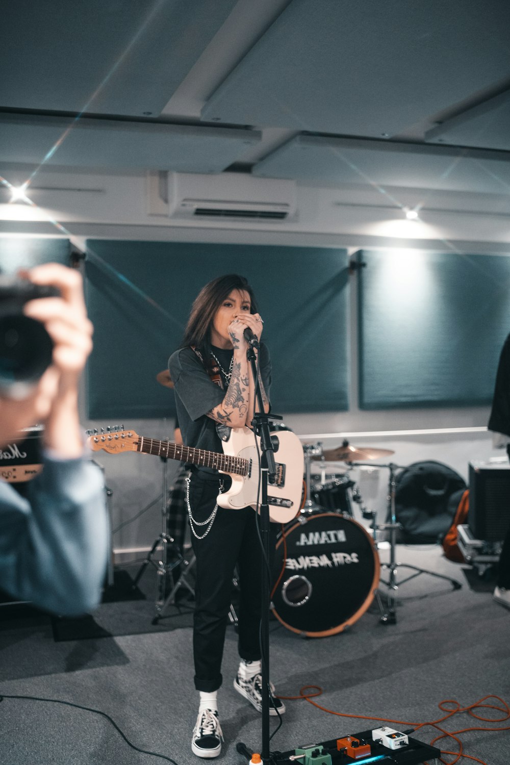 woman in black long sleeve shirt singing on stage