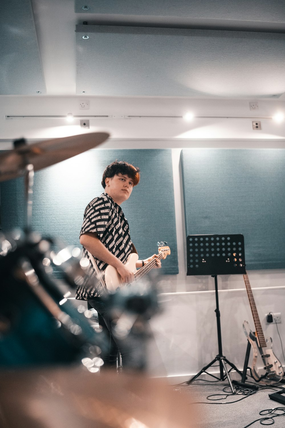 man in black and white checkered dress shirt playing guitar