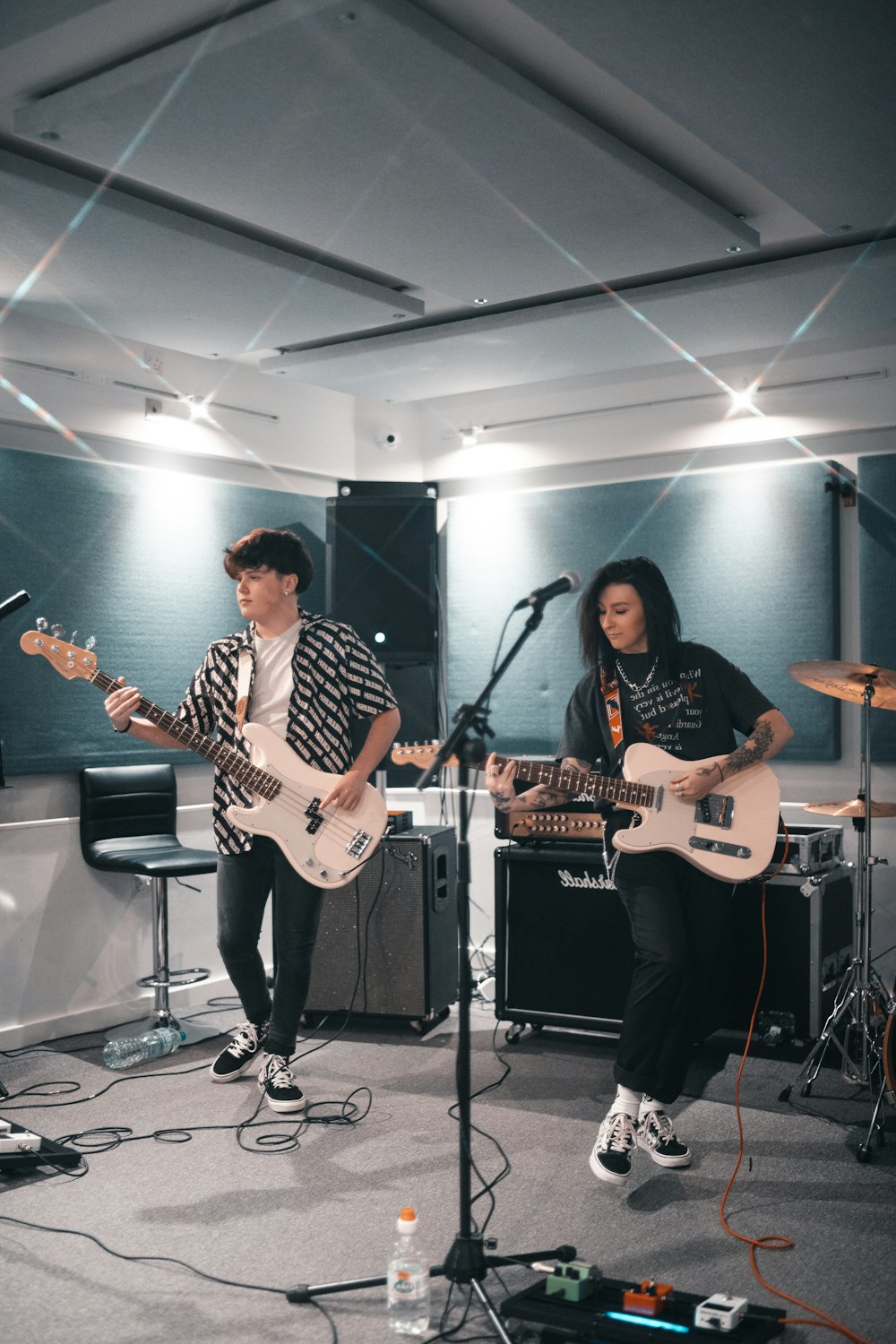 man playing electric guitar beside woman playing guitar