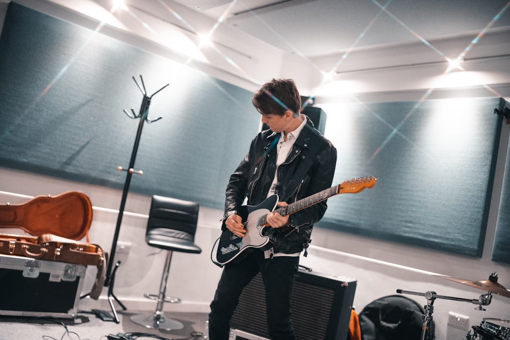 woman in black blazer playing guitar