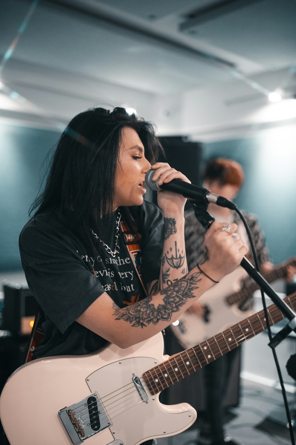 woman in black long sleeve shirt playing guitar