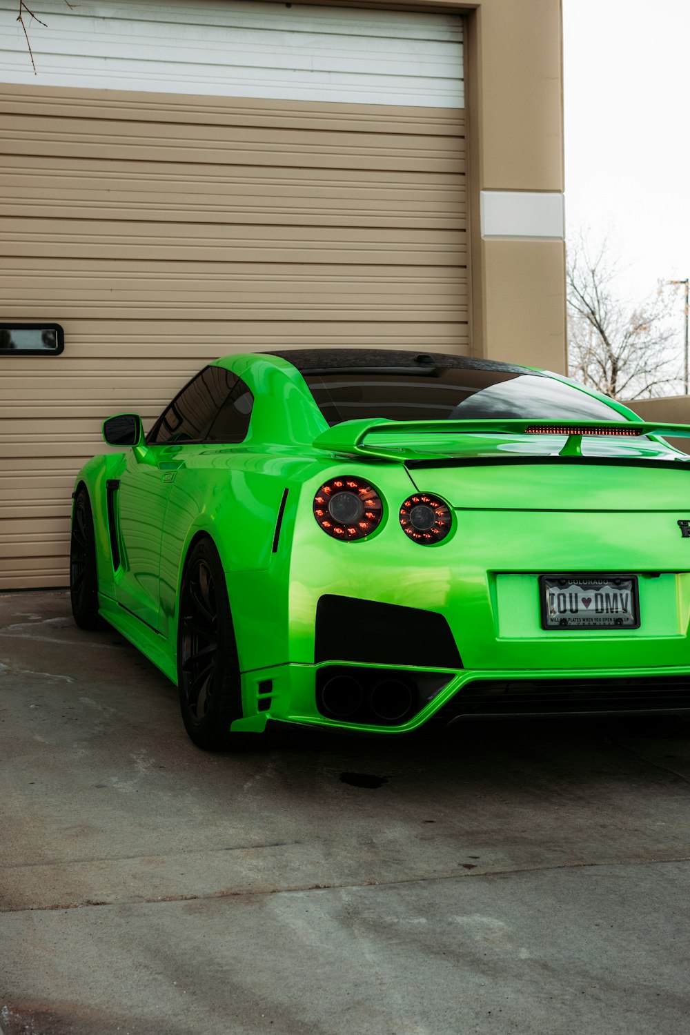 green bmw m 3 coupe parked near white garage door