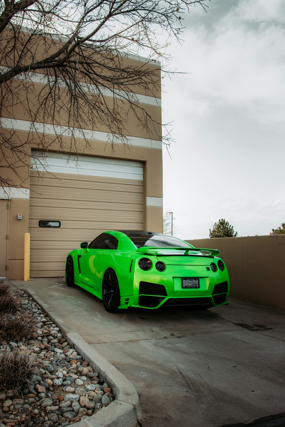 green porsche 911 parked in front of white building