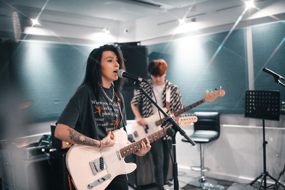 man in black crew neck t-shirt playing electric guitar