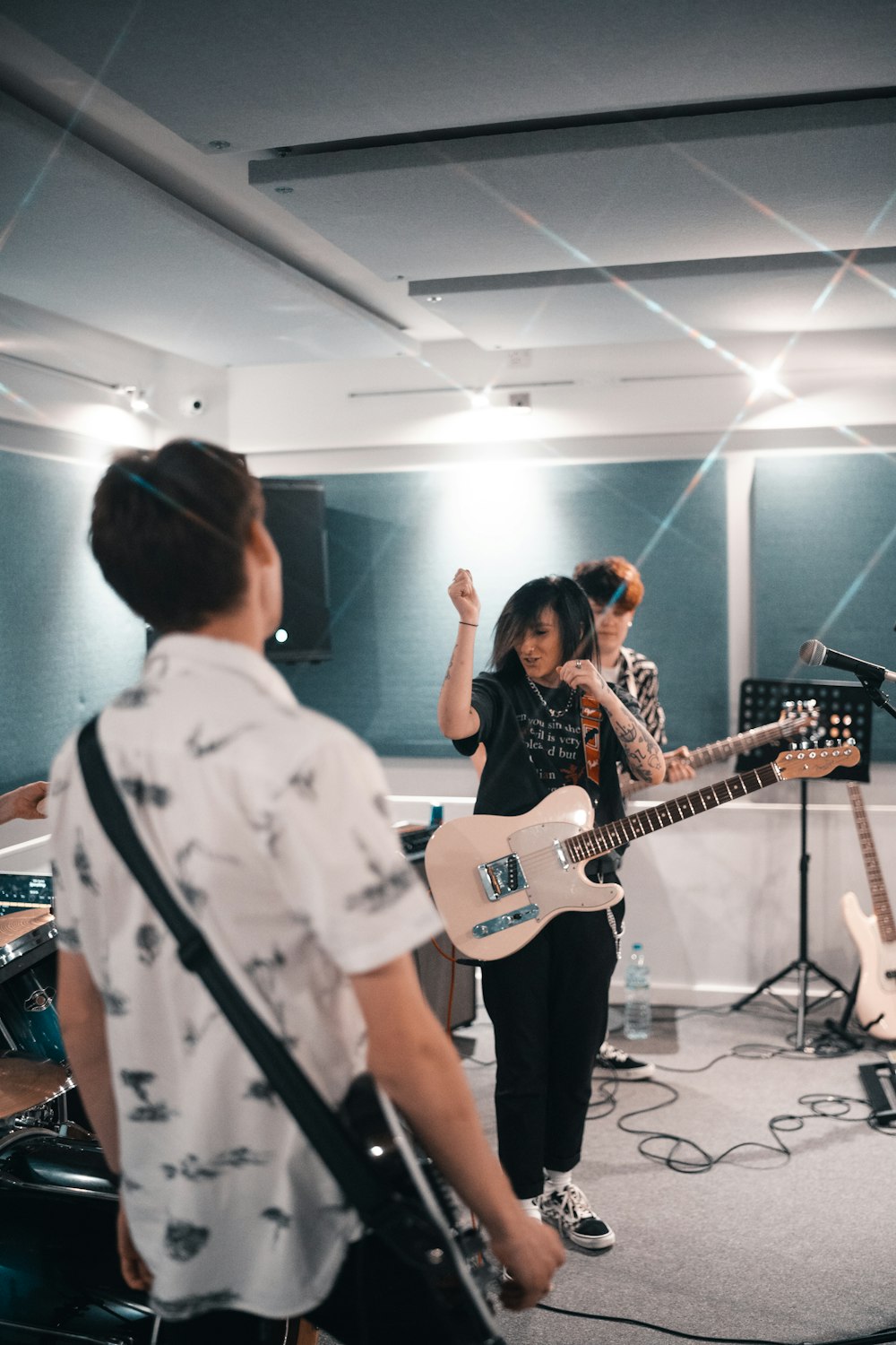 man in white dress shirt playing electric guitar