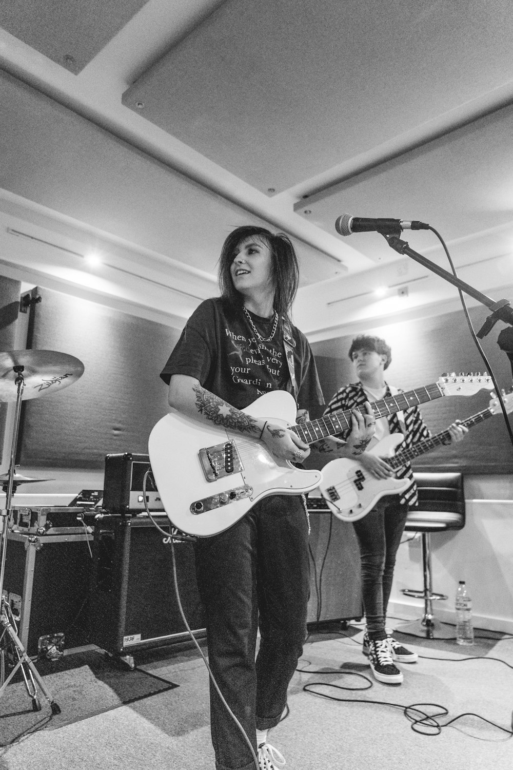 woman in black shirt playing white electric guitar