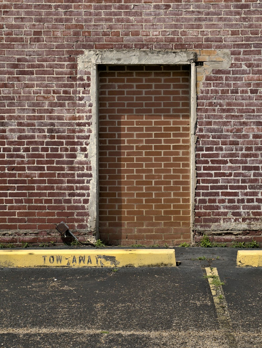 brown brick wall with black and yellow caution sign