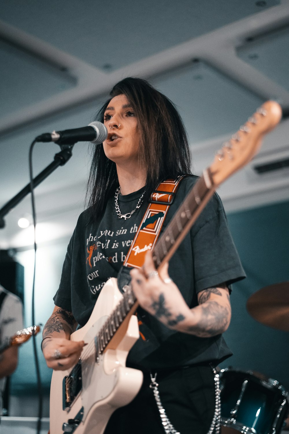 woman in black denim jacket playing guitar