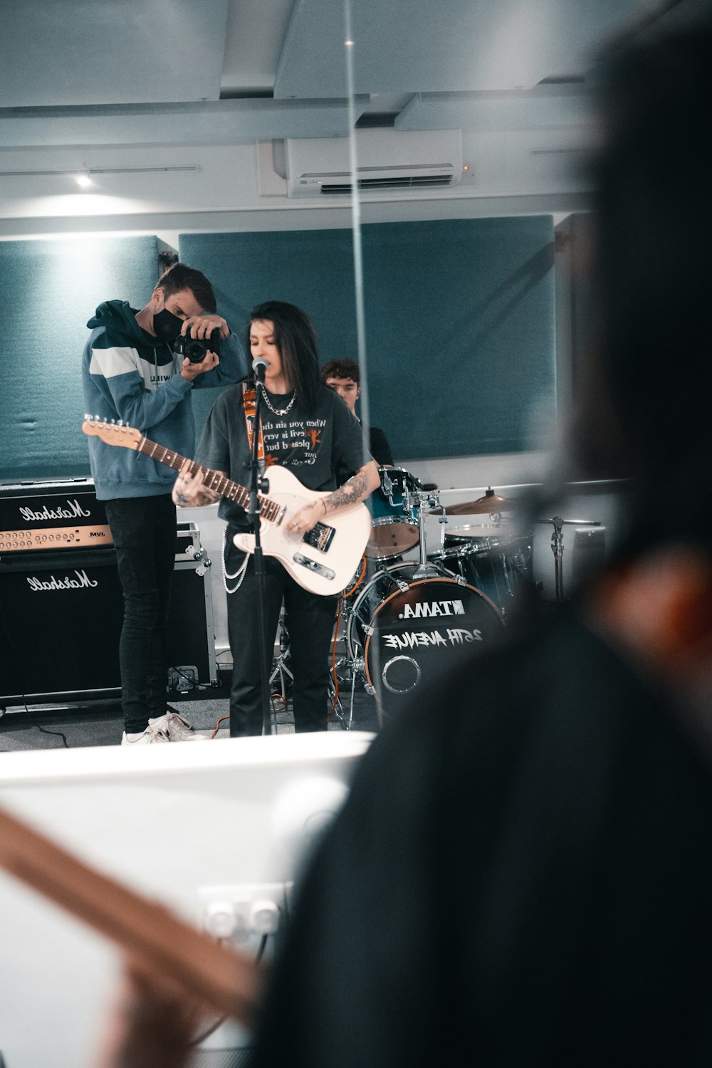 man in black suit playing electric guitar