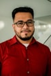 man in red button up shirt wearing black framed eyeglasses