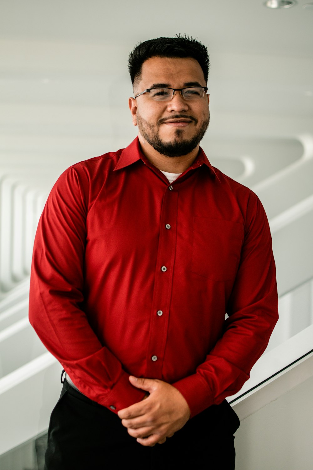 man in red dress shirt wearing black framed eyeglasses