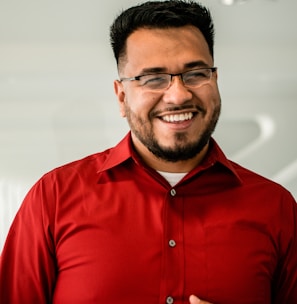 man in red button up shirt wearing black framed eyeglasses