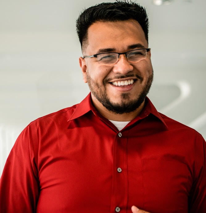 man in red button up shirt wearing black framed eyeglasses