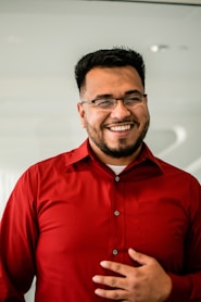 man in red button up shirt wearing black framed eyeglasses