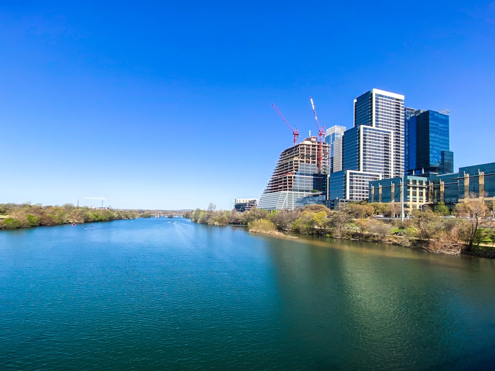 city skyline near body of water under blue sky during daytime