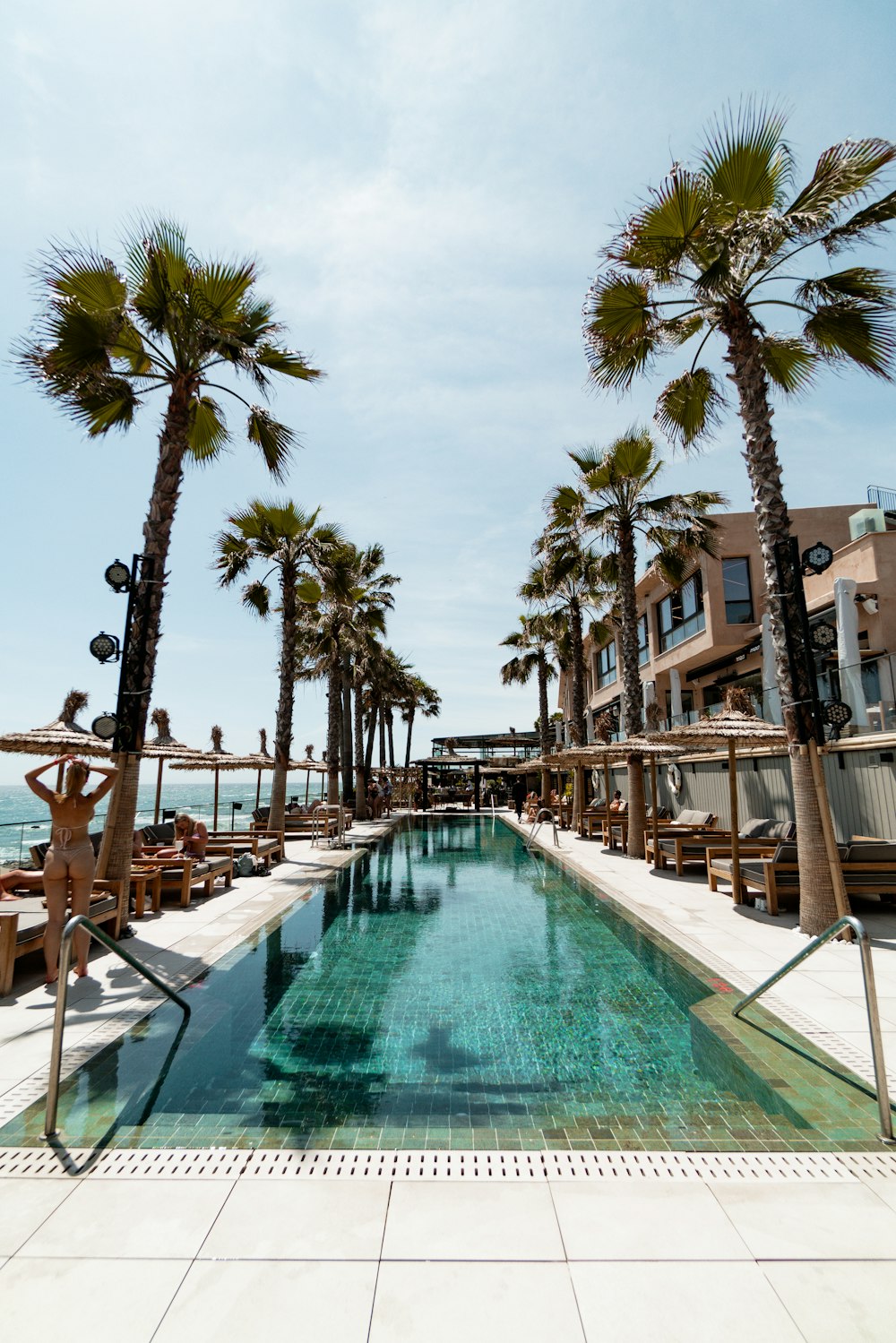 brown wooden chairs near swimming pool during daytime