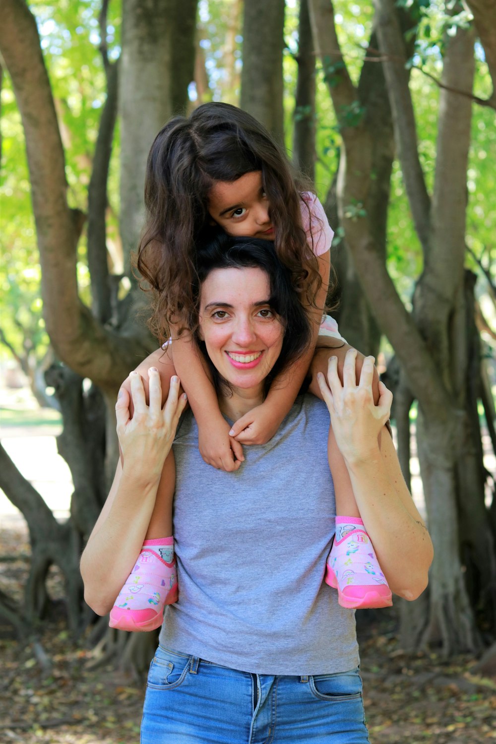 woman in gray tank top hugging woman in pink floral dress