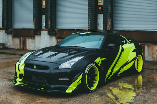 A sleek black sports car glowing under neon green lights after a master-level exterior detail.