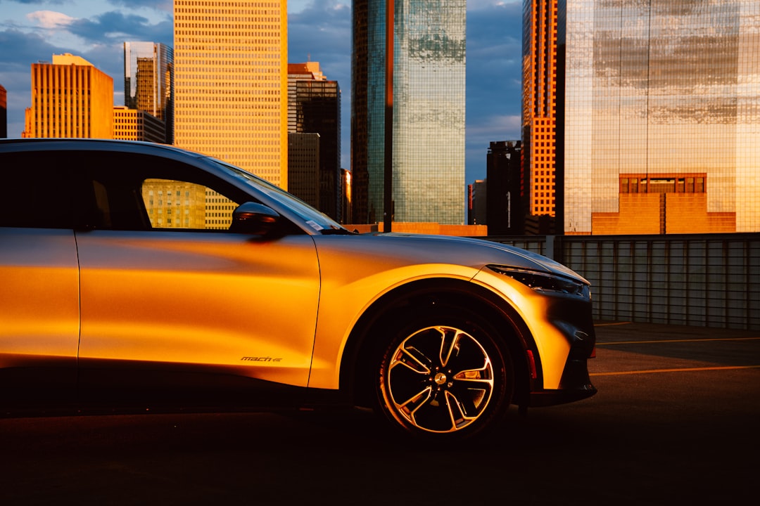 yellow car in front of city buildings during daytime