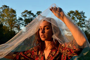 The founder smiling gently while holding a piece of fabric outdoors in natural light