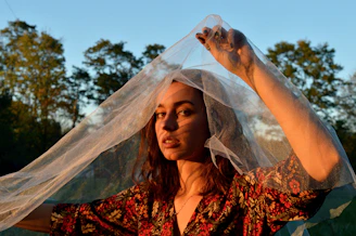 The founder smiling gently while holding a piece of fabric outdoors in natural light
