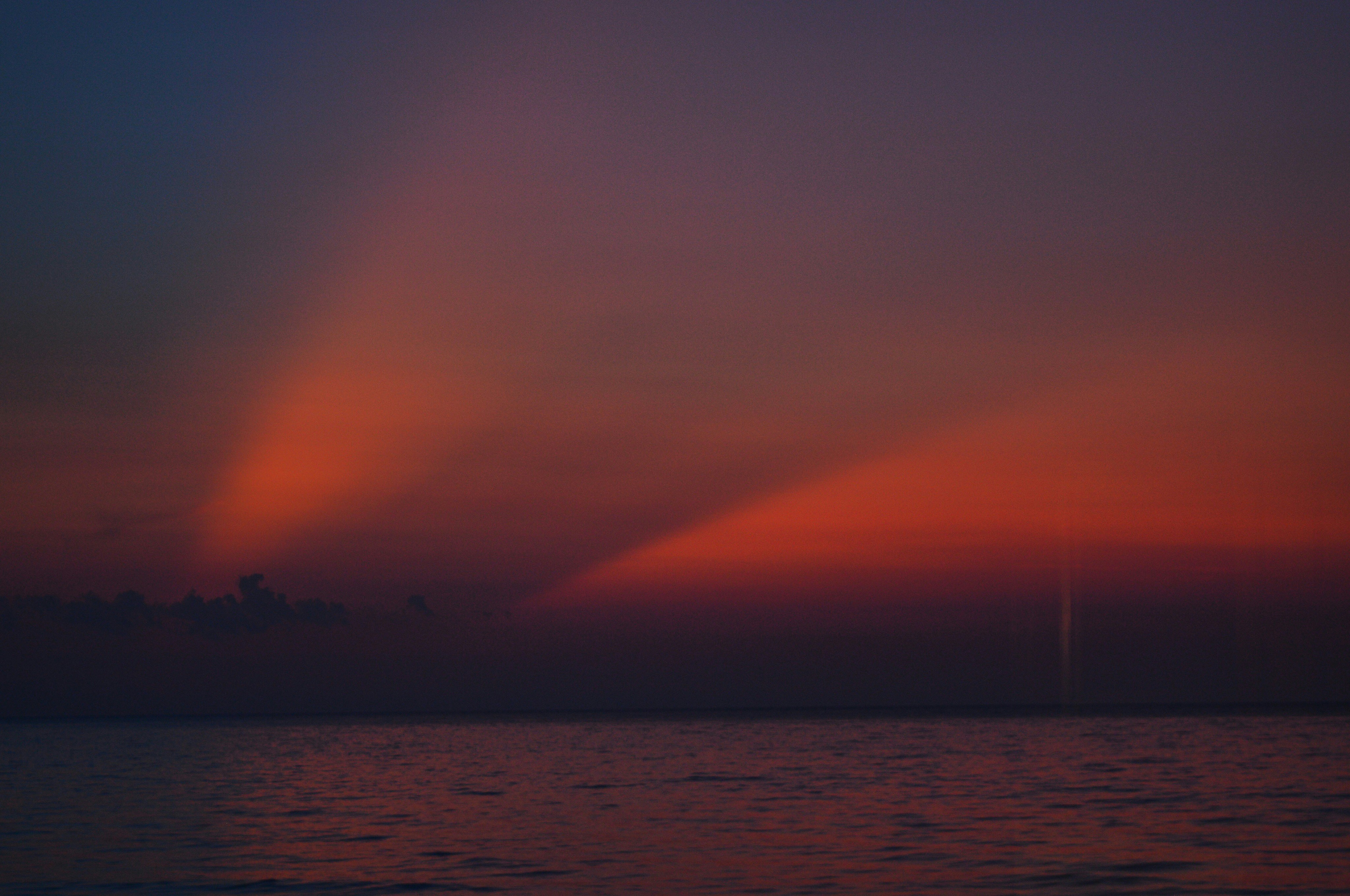 Raggi al tramonto su un oceano calmo al crepuscolo
