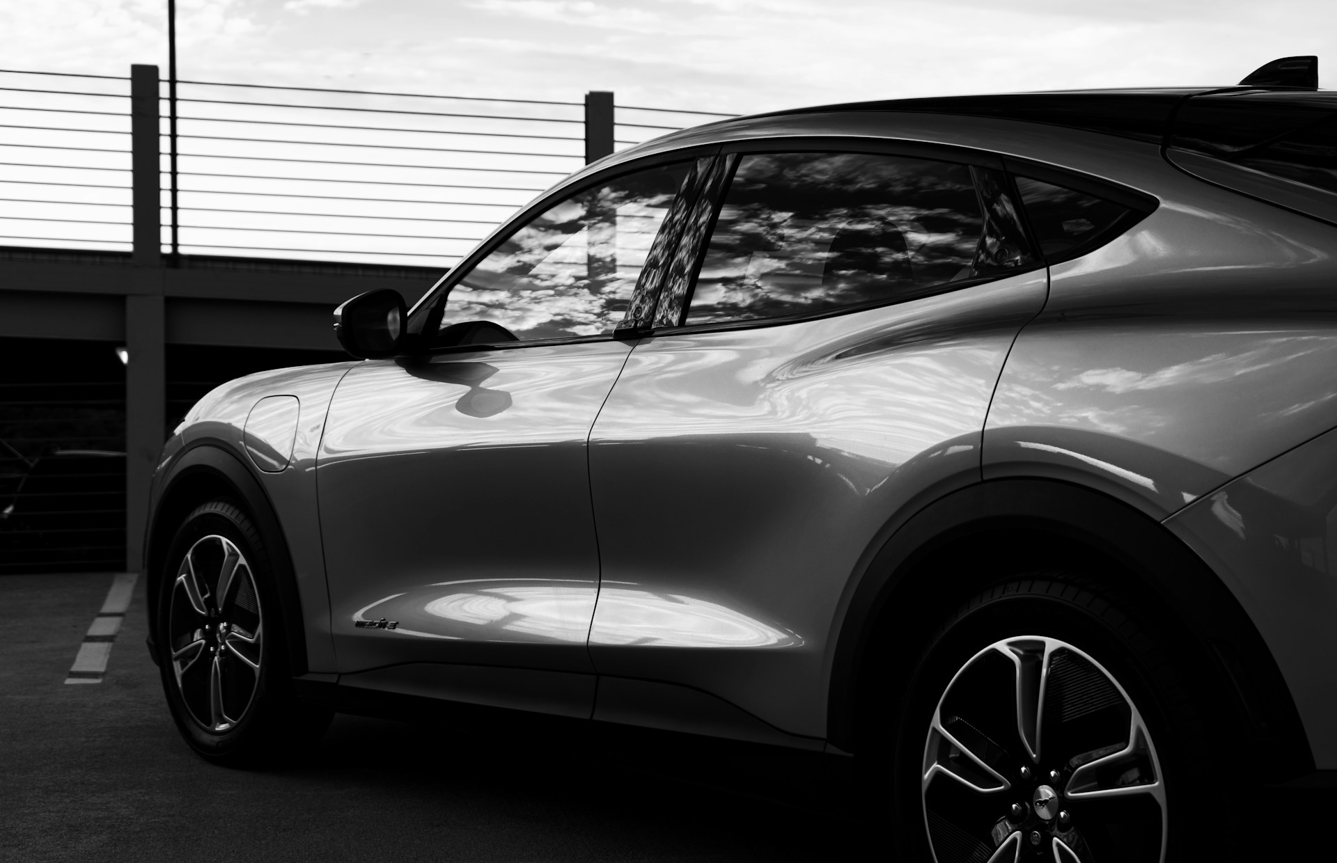 grayscale photo of car in front of garage door