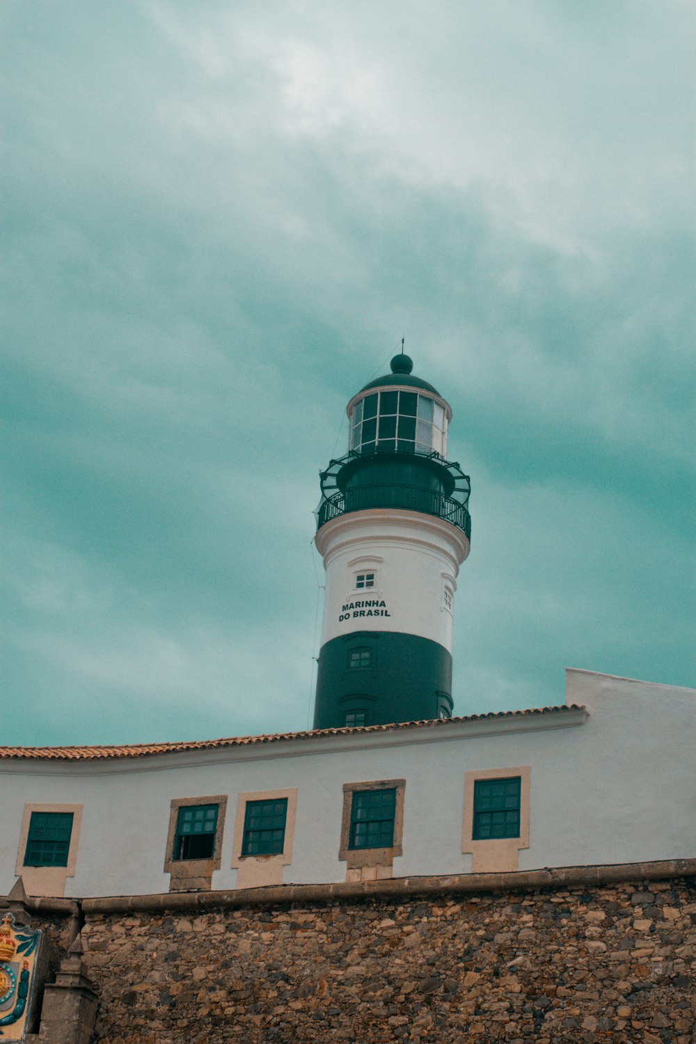 white and black lighthouse under white clouds and blue sky during daytime