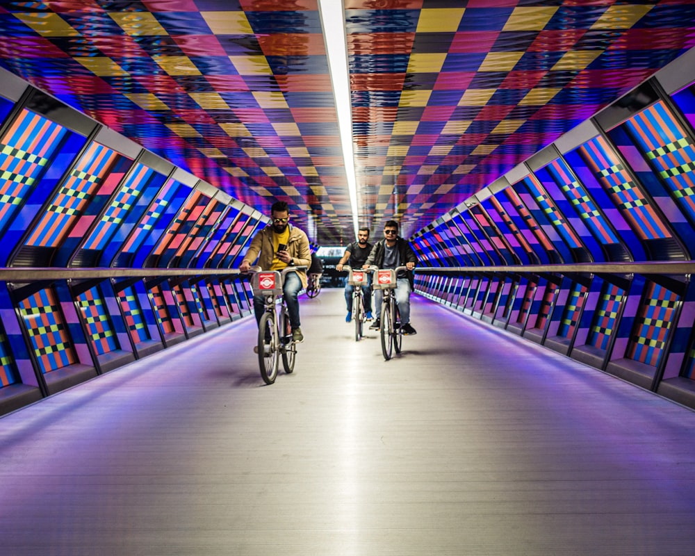 people riding bicycle on tunnel